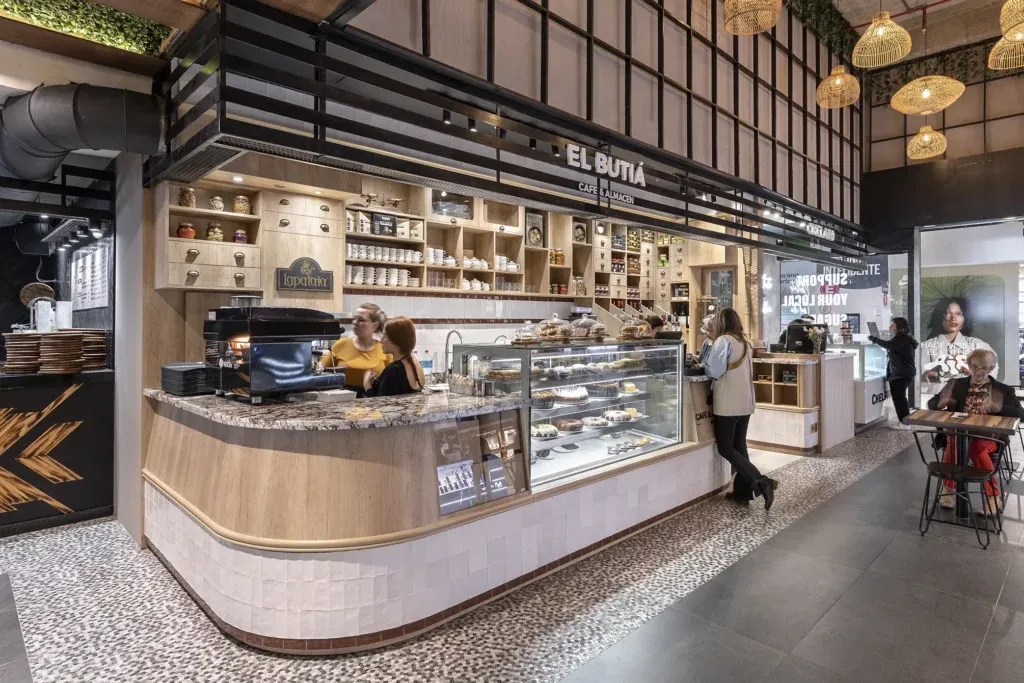 Local de El Butiá en el Mercado Gastronómico de Tres Cruces, con el cartel del café, la barra curva y la vitrina de tortas.
